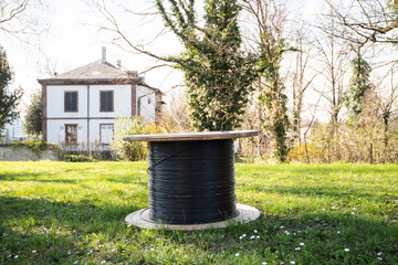 Fiber optic roll in garden with house in background on a sunny spring day