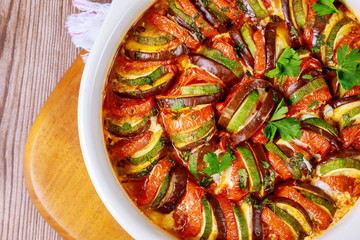 Cooked vegetable ratatouille with mozzarella cheese in white oven pan.