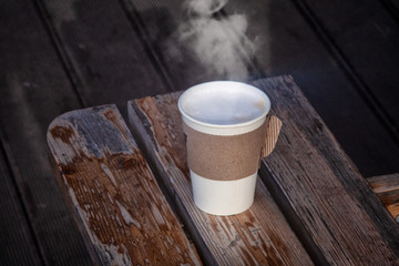 Single paper takeaway cup of coffee on the wood table