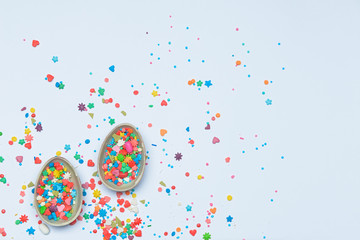 Chocolate eggs and sprinkles on white background