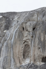 Fototapeta na wymiar Scary Face in Travertine Rock Flow