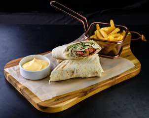 shawarma and french fries on a wooden board