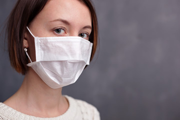 Young caucasian nurse wearing mask looking at camera.