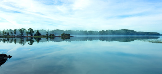 Landscape photo by the lake. Look almost like an watercolor painting. Foggy morning in Sweden.