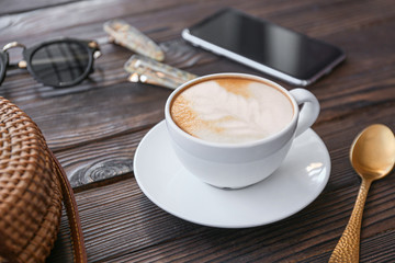 Cup of tasty cappuccino on wooden table