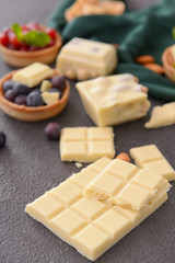 Sweet white chocolate with nuts and berries on table