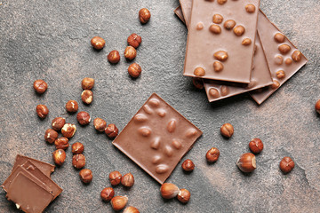 Fototapeta na wymiar Sweet chocolate with nuts on grunge table