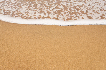 White foam on a sandy beach. Copy space.