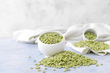 Bowl with green coffee beans on table