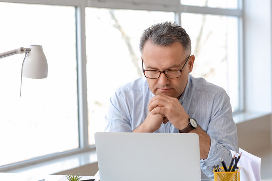 Mature Man Using Laptop At Home