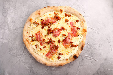 Delicious fresh Pizza with tomatoes, mashrooms, bacon and cheese mozzarella on the stone table. Top view