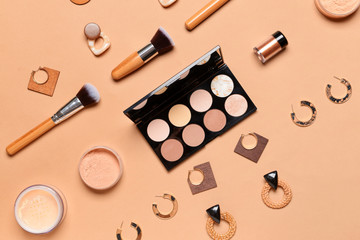 Makeup cosmetics with accessories on color background