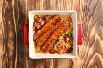 bavarian sausage with cabbage closeup on wooden background. octoberfest concept top view
