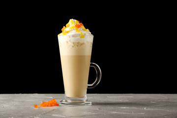 orange latte in glass isolated on black