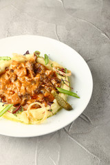 beef stroganoff closeup with mashed potatoes on light background