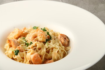 pasta with seafood closeup. pasta with shrimp and salmon in white plate