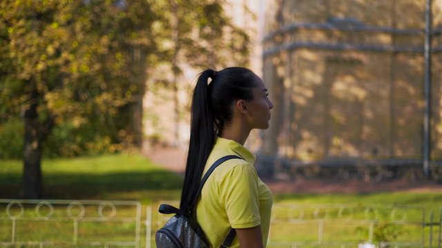 young attractive girl walks at sunset in the park. Soft light. 4K