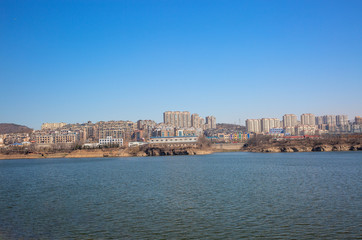Fototapeta premium Zimowa tama na zewnątrz i miasto Xishan Lake w Dalian w Chinach