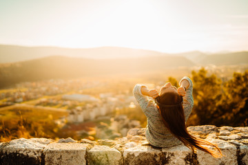Optimistic young woman listening to music podcast stream over headphones,enjoying in nature at...