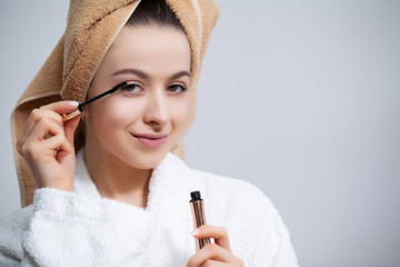 Pretty girl doing cosmetic procedures at home in front of mirror