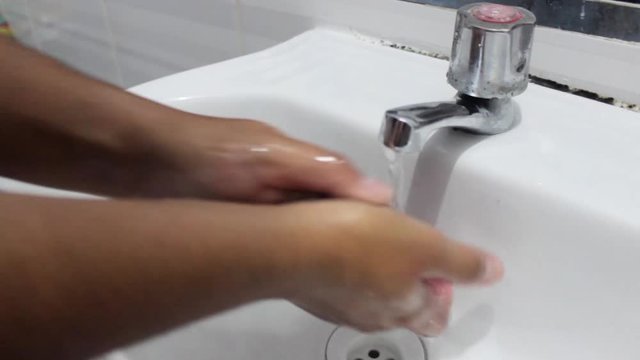 mujer latina realizándose lavado de manos