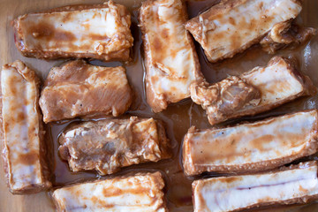 Raw marinaded juicy pork ribs ready for cooking. Meat processing picture. Food photography close up background