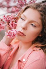 Naklejka premium Girl in a cherry blossom garden