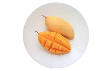 Golden mango fruit in white plate isolated on white background. Ripe yellow Barracuda mangos....
