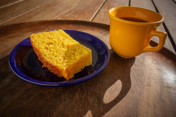 Delicious slice of corn cake with guava syrup accompanied with a cup of coffee