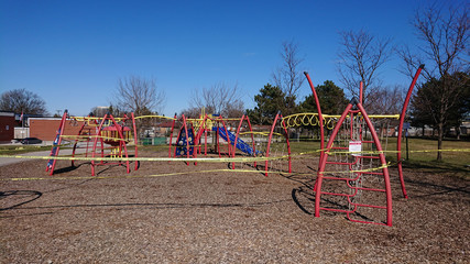 Children's playground is closed with yellow caution tape due coronavirus COVID-19 pandemic. No children allowed on the Playground  Ban on children's playgrounds. Flatten the curve fight the virus. 