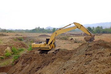 Fototapeta na wymiar Excavator working digs the ground for water drainage in agriculture system.