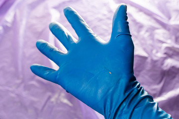 used blue protective glove with perforating hole on the inside of the palm