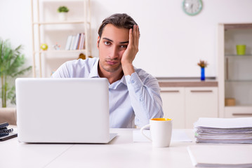 Young male businessman working at home