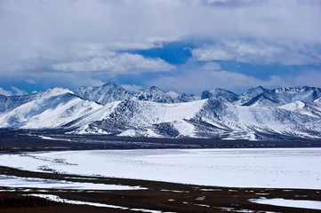 Fototapeta na wymiar iced lake and snow covered mountains in winter, Tibet China