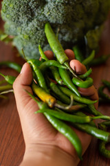 An unrecognizable person is grabbing a Handful of fresh chili peppers