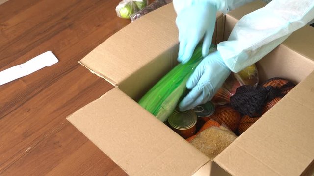 Takeaway and door delivery of goods. Order picker in protective suit, gloves and mask. Coronavirus disease (COVID-19) pandemic. Online contactless food shopping
