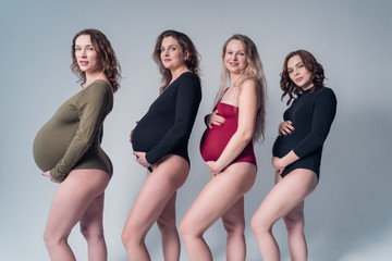 Closeup portrait of young pregnant girls in swimsuits.