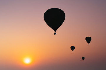 Silhouette balloons on sunset sky background