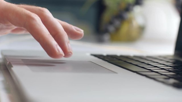 Man's finger pressing the spacebar and scrolling the touch pad of a laptop.