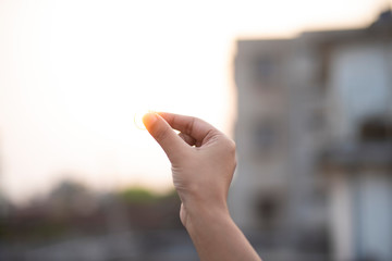 Image of fingers holding a ring during sunset. Back light photography.