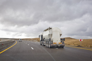 Asphalt road and bright blue sky with fluffy clouds . Empty desert asphalt road from low angle with mountains and clouds on background. road, red desert landscape . Open road with blue clouds .