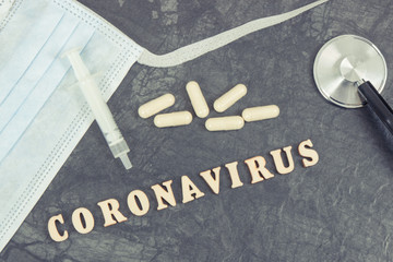 Inscription coronavirus with protective mask, tablets, syringe and stethoscope. Novel Chinese...
