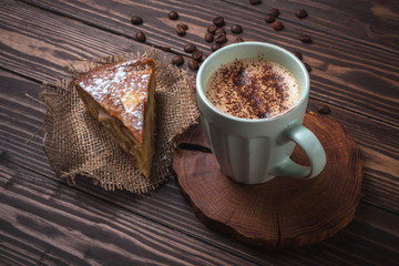 Cup with coffee and apple pie on a rural wooden tabletop. Latte or cappuccino with chocolate sprinkles. Apple Charlotte