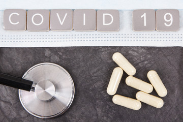Inscription covid-19 with protective mask, tablets and stethoscope. Novel coronavirus. 2019-nCoV....