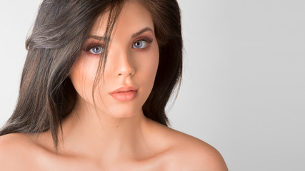 Portrait of a beautiful young woman over grey background.