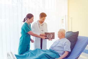 Asian male Patient On Ward. Strong Asian Man Go to Visit Doctor For Check His Health Of The Year. Caregiver In elderly home care giving help on the bed. Hospital and Medicine and health care Concept