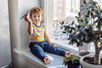 Boy sitting near window. Stay home concept, Coronavirus Covid-19 quarantine