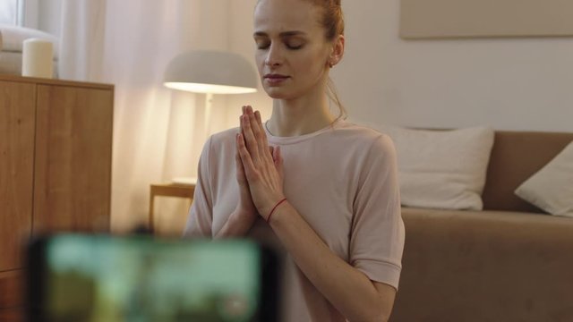 CU Attractive Caucasian female recording making live stream or vlog about doing yoga at home. Stay home, quarantine workout. Shot on ARRI Alexa Mini with Cooke S4 lenses