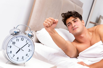 Young man having trouble waking up in the morning