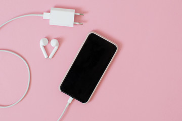 Top view of a smartphone with headphones and charge.